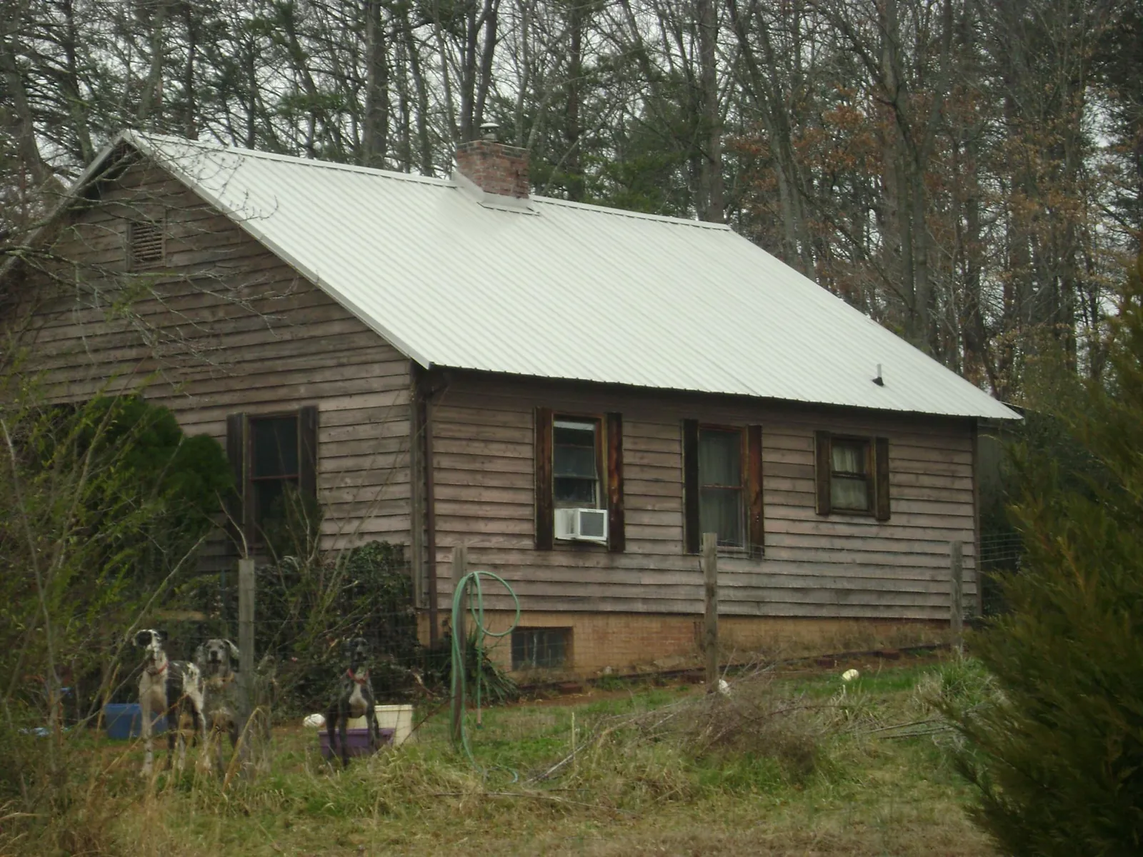 White metal roof on an old wood sided farmhouse, from a Metal Roof Installation job in Vienna